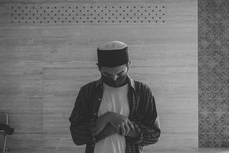 Muslim man praying shalat at mosque with mask during the covid-19 or corona virus pandemic