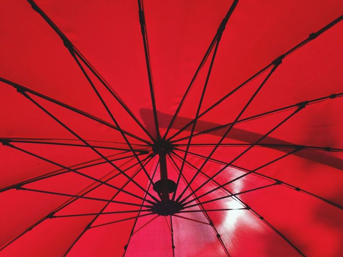 Low angle view of umbrella on red ceiling