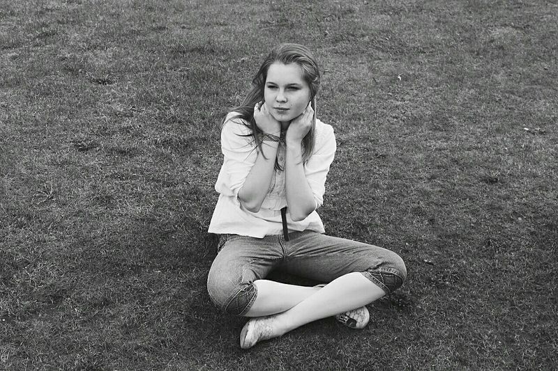 High angle view of woman sitting on grassy field at park