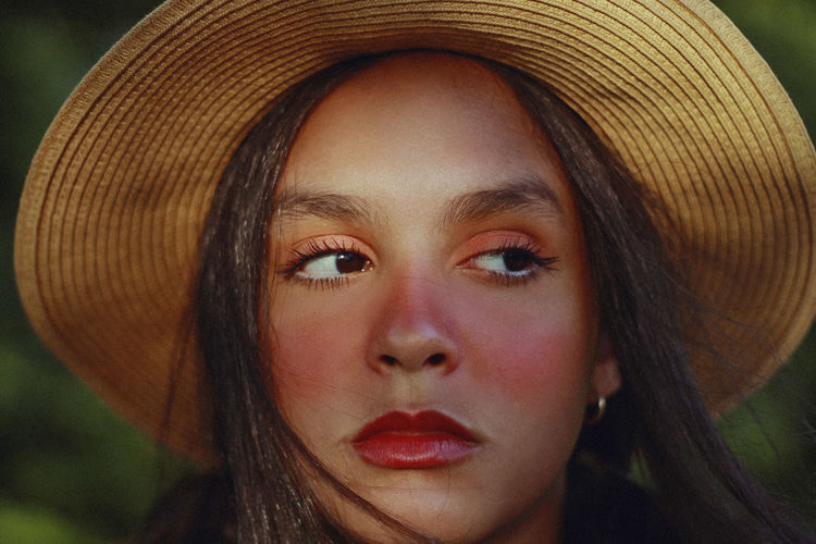 Close-up of teenage girl wearing hat looking away