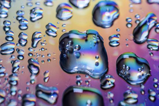 FULL FRAME SHOT OF MULTI COLORED WATER ON TABLE