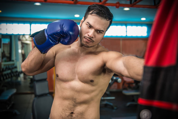 Shirtless muscular man exercising at gym