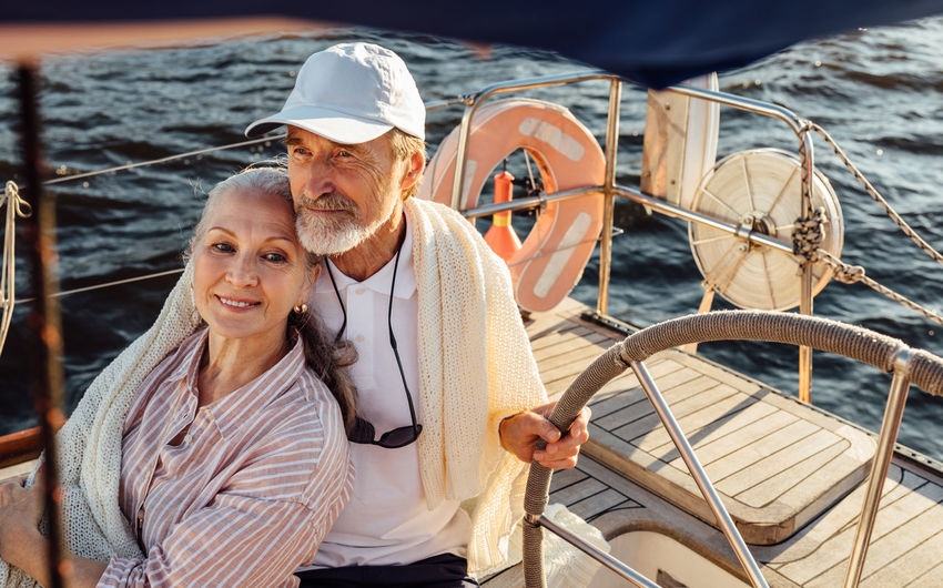 Senior couple embracing while sitting in boat at sea