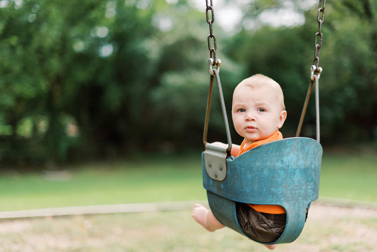 Portrait of cute boy on swing at playground
