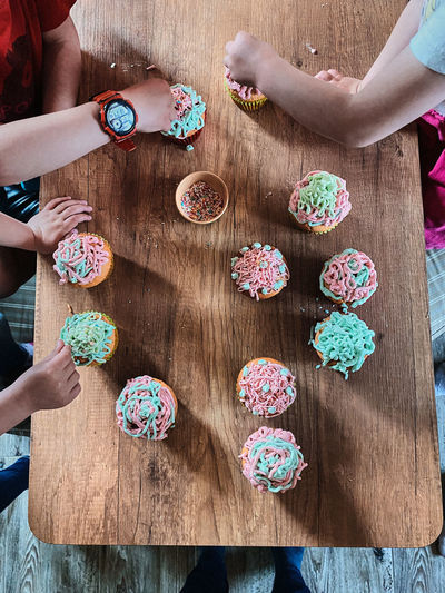 Group of children baking cupcakes, preparing ingredients, topping, sprinkles for decorating cookies