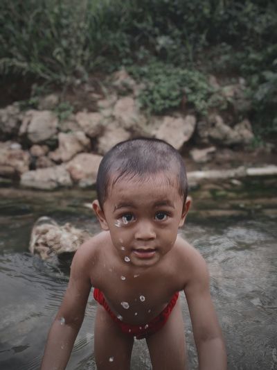 Portrait of cute boy in water