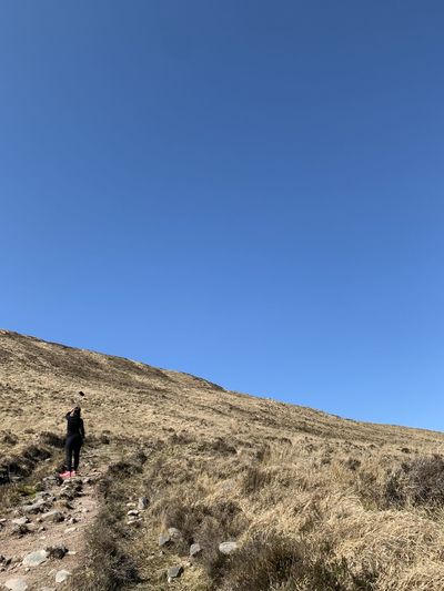 Woman on edge of mountain with nothing but sky