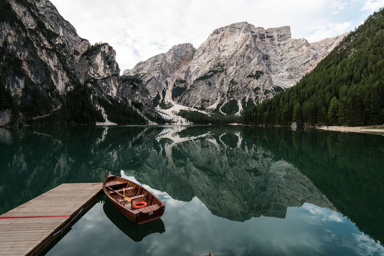 Boat moored on lake against mountains