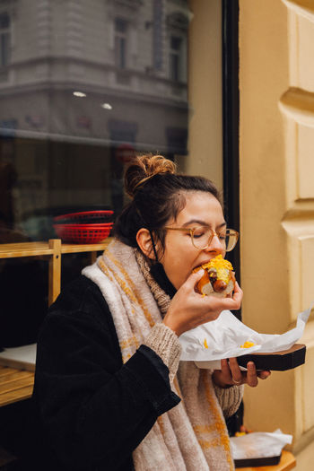 YOUNG WOMAN EATING FOOD AT RESTAURANT