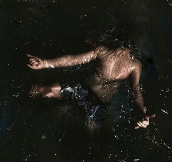 High angle view of woman lying down in water