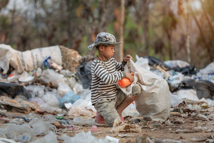Boy wearing hat collecting garbage