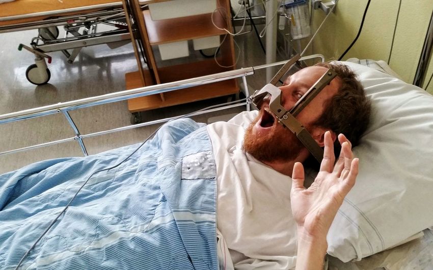High angle view of patient shouting with equipment on face lying at hospital