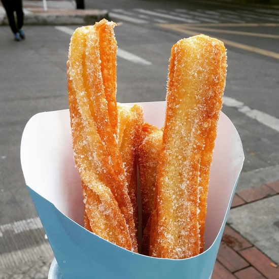 Close-up of churros in container at street