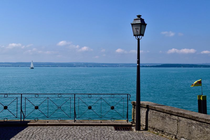 Street light by sea against sky