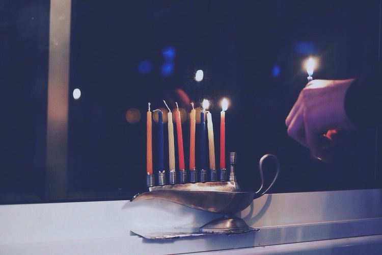 Cropped image of person arranging candles at home