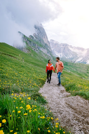 Full length of couple standing on trail against landscape