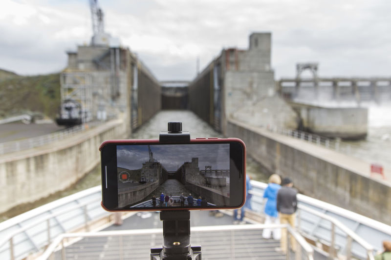A cell phone records a timelapse of a ship going through a lock.