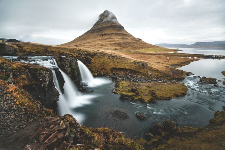 Scenic view of waterfall against sky