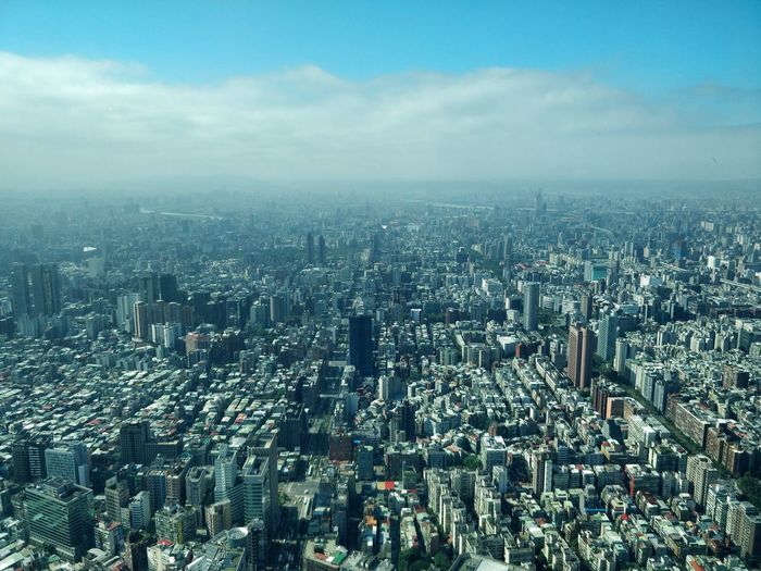 High angle view of cityscape against cloudy sky
