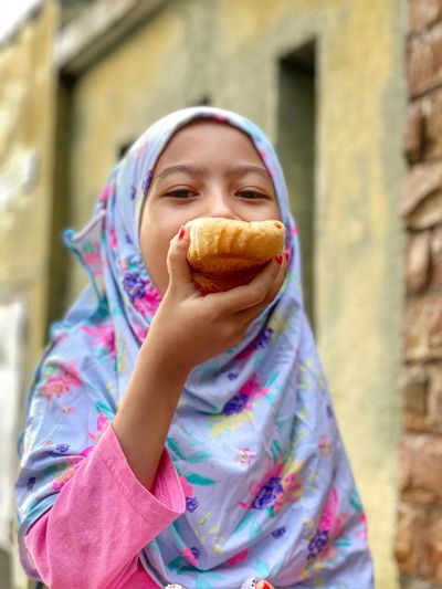 Portrait of an asian girl eating bread