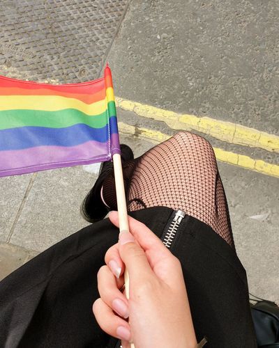 Low section of woman holding pride flag on street