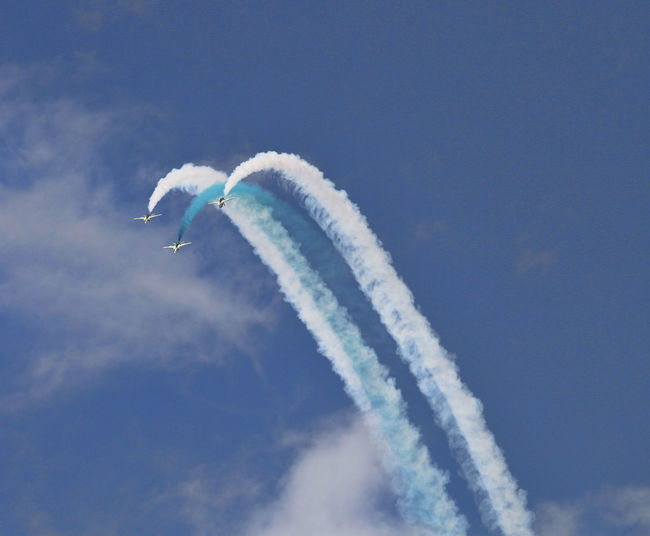 Low angle view of airshow against sky