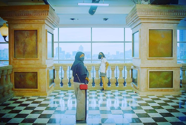 Woman standing by window in building