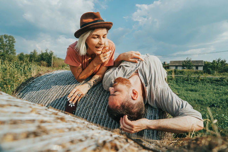 Smiling couple relaxing on hay bales