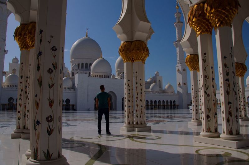 Rear view of man standing by columns at sheikh zayed mosque