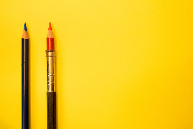 Close-up of pencil against yellow background