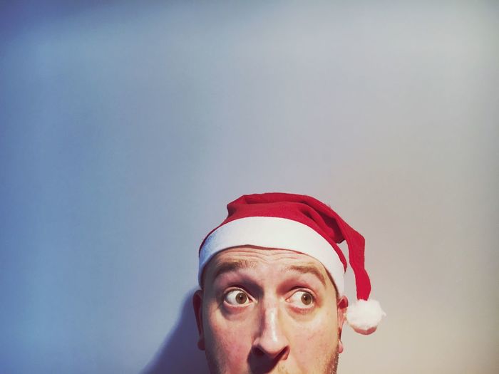Man looking away in santa hat against white background