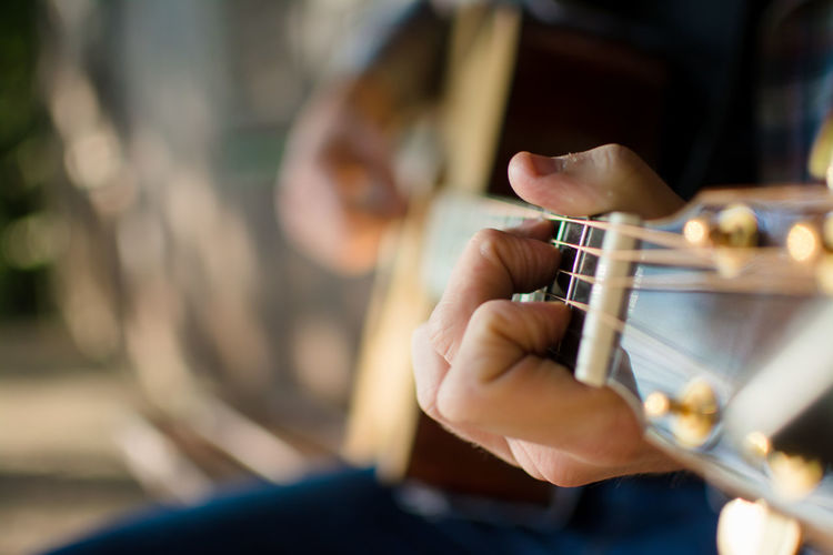 Midsection of man playing guitar