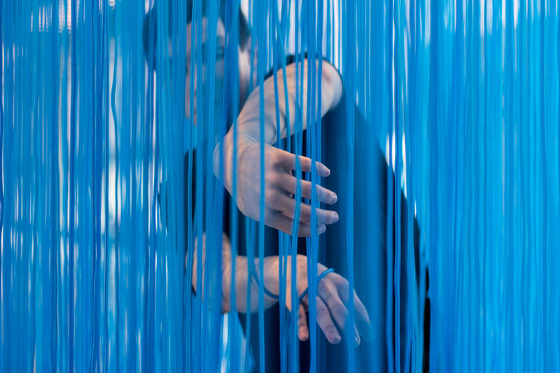 Man standing behind blue textile