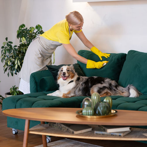 Side view of man with dog sitting on sofa at home