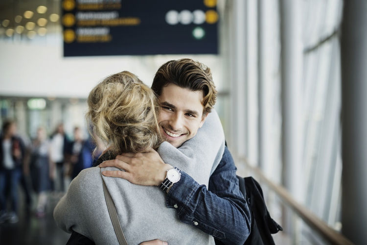 Happy businessman embracing female colleague at airport