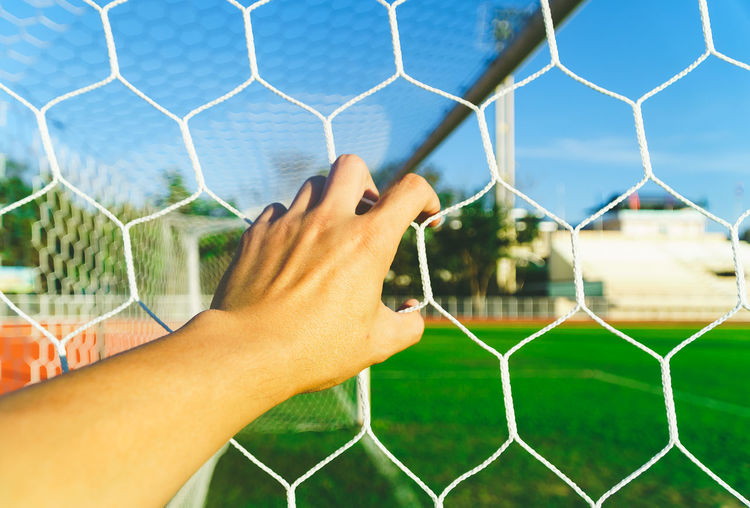 Close-up of hand on goal post