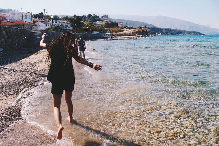 Girl jumping on shore at beach