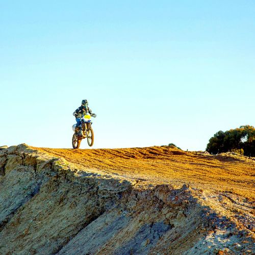 Low angle view of motocross biker on track against sky