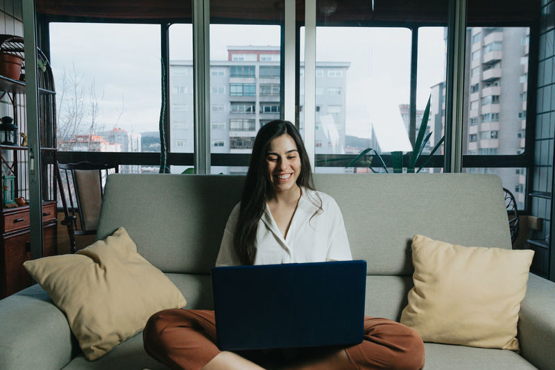 Young businesswoman laptop while sitting on sofa