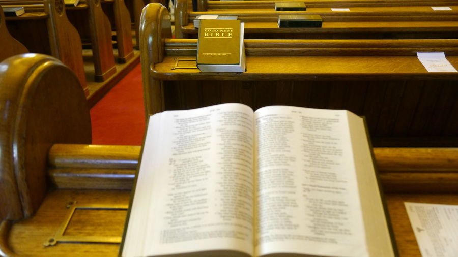 High angle view to holy bible on pew in church 