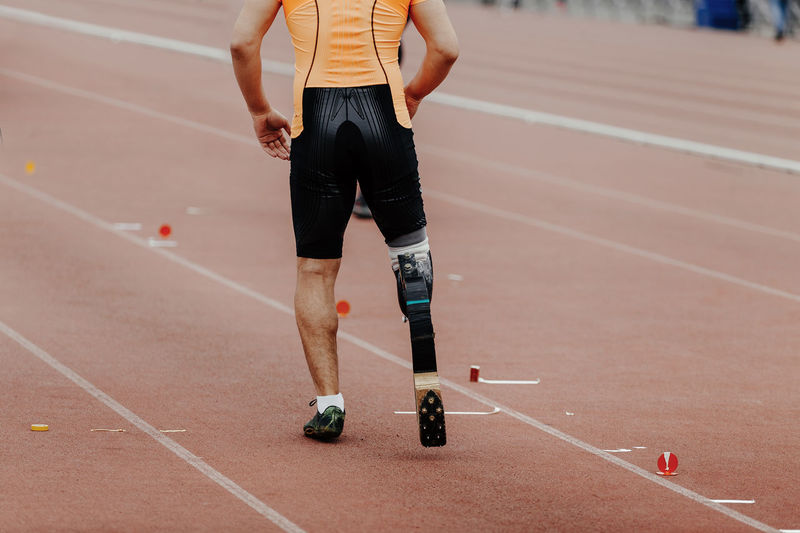 Low section of man with amputated leg running on track