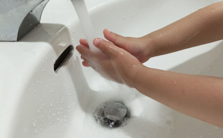 Cropped image of hand touching water at home