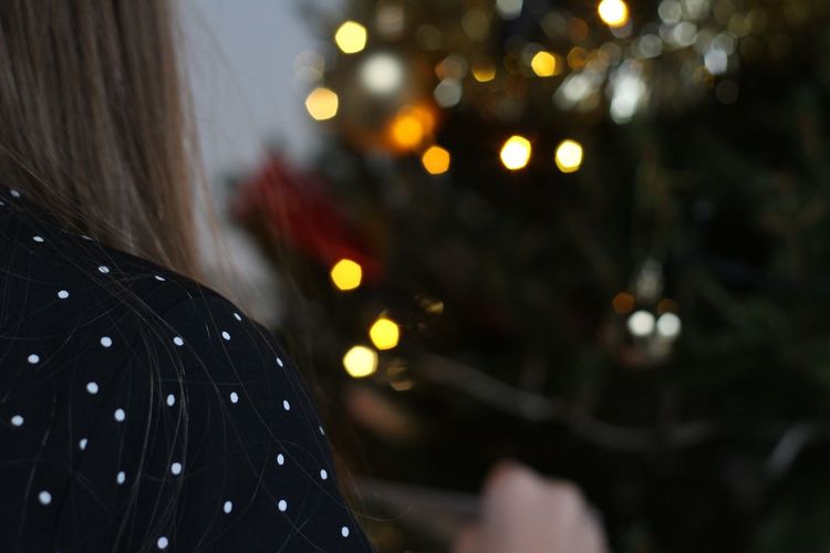 Close-up portrait of woman with christmas lights