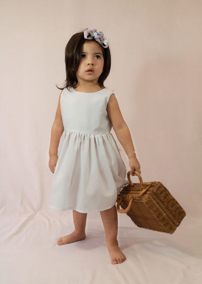 Portrait of cute girl standing in basket