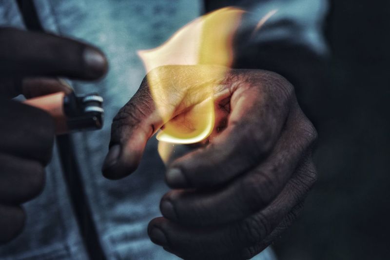 Close-up of man holding flame