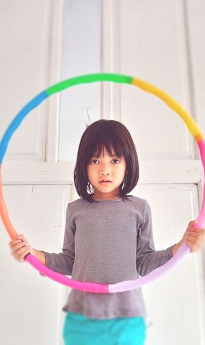A little girl holding a plastic hula-hoop to play in kedungkandang malang indonesia