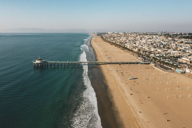 Aerial view over manhattan beach in california with green blue water and blue sky