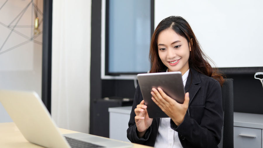 Young woman using digital tablet in office