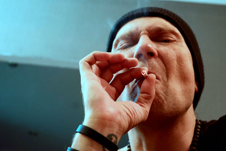 Close-up portrait of man holding cigarette