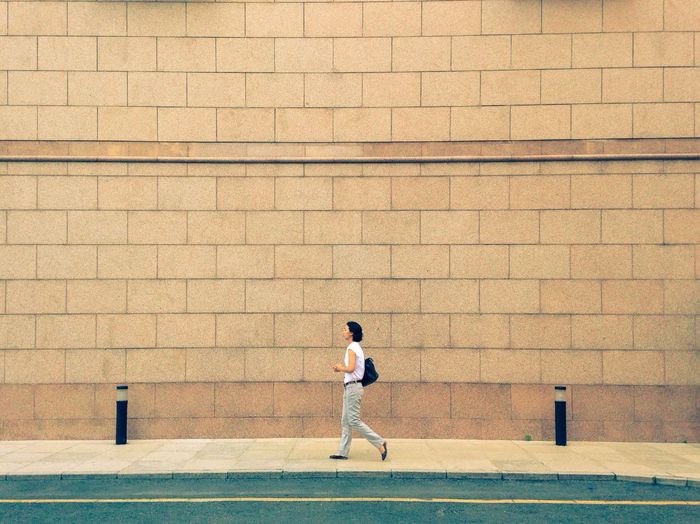 Full length of young man standing on wall